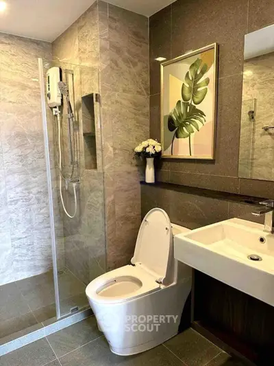 Modern bathroom with glass shower, elegant sink, and stylish decor