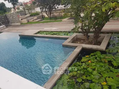 Luxurious outdoor pool with lush greenery and serene surroundings, perfect for relaxation and leisure.