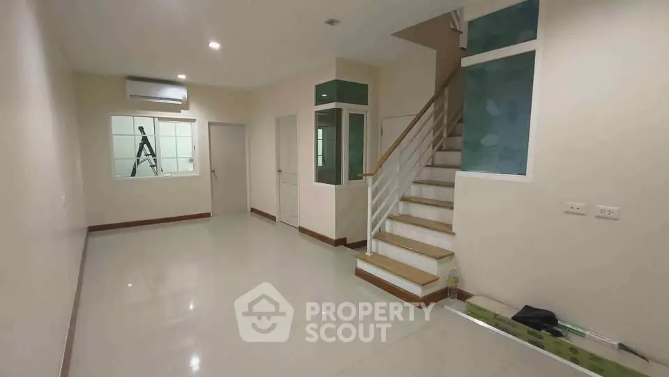 Spacious modern living room with staircase and air conditioning