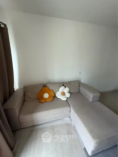 Cozy living room with modern sectional sofa and decorative flower cushions.