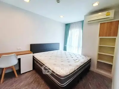 Modern bedroom with double bed, desk, and air conditioning in bright apartment.