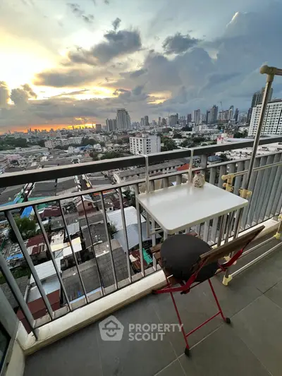 Stunning city view from a high-rise balcony with cozy seating, perfect for relaxation and enjoying sunsets.