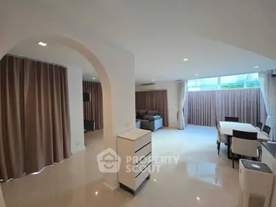 Spacious modern living and dining area with elegant archway and natural light.