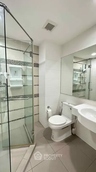 Modern bathroom with glass shower and sleek fixtures in a contemporary apartment.