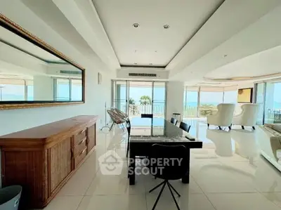 Spacious living room with ocean view, elegant decor, and abundant natural light.