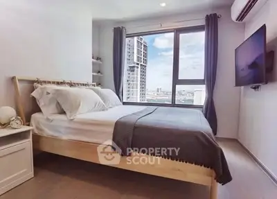 Modern bedroom with city view and wall-mounted TV in high-rise apartment.
