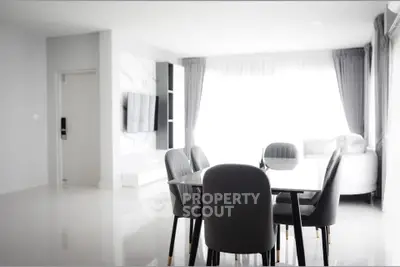 Modern open-plan living and dining area with sleek furniture and abundant natural light.