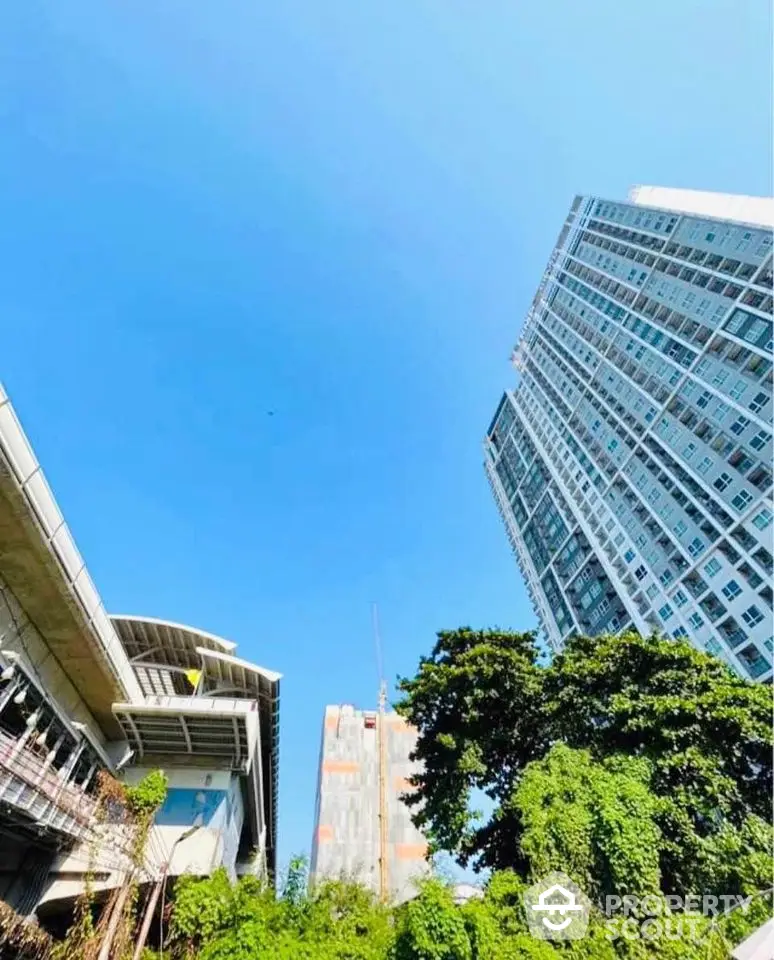 Stunning high-rise building with lush greenery and clear blue sky view