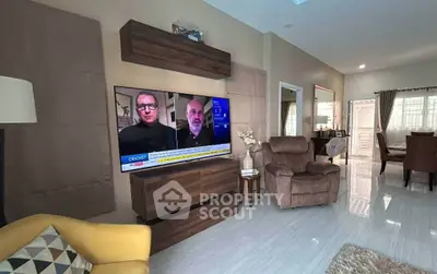 Spacious living room with modern decor and large TV, perfect for relaxation.