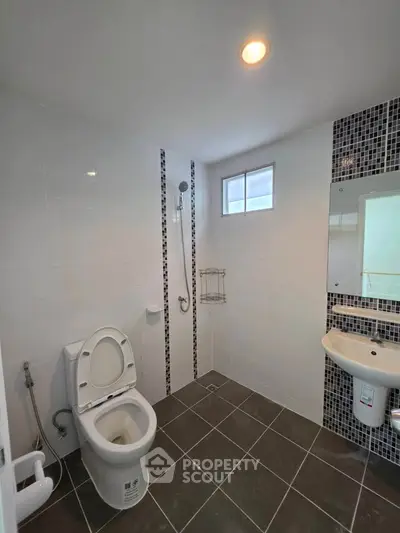 Modern bathroom with sleek tiles and contemporary fixtures in a real estate property.