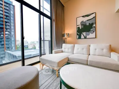 Modern living room with large windows and city view, featuring stylish furniture and contemporary art.
