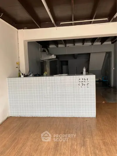 Spacious interior with tiled counter and wooden flooring, ideal for customization.