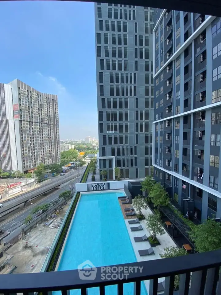 Modern high-rise building with a stunning pool view and urban skyline backdrop.