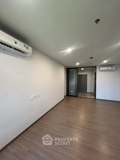 Spacious modern living room with wooden flooring and air conditioning