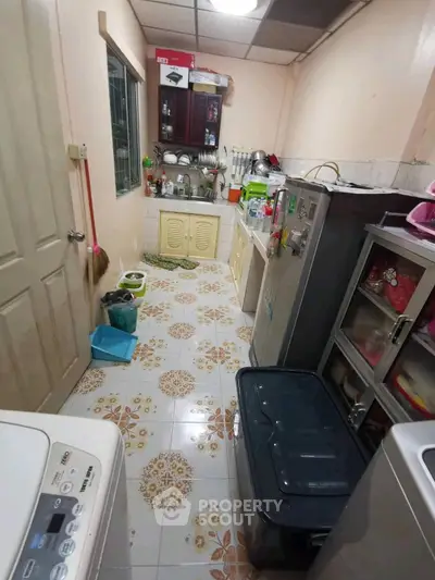 Compact kitchen with tiled floor and modern appliances in cozy home