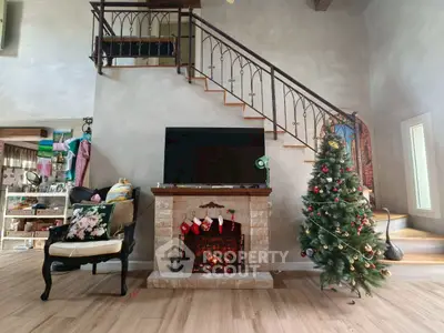 Charming living room with cozy fireplace and festive decor, featuring a stylish staircase and elegant flooring.
