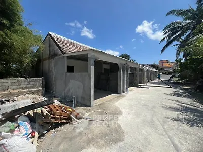 Under-construction building with open garages and clear blue sky