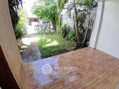 Charming garden view from a tiled patio, perfect for outdoor relaxation and entertainment.