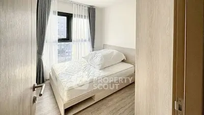 Bright and cozy bedroom with large window and modern furnishings in a stylish apartment.