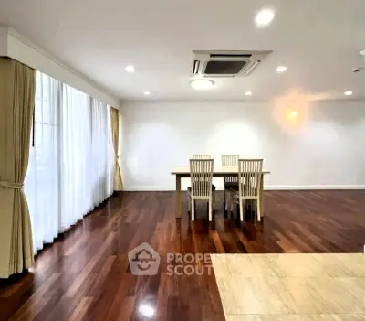 Spacious dining area with elegant wooden flooring and natural light, perfect for family gatherings.