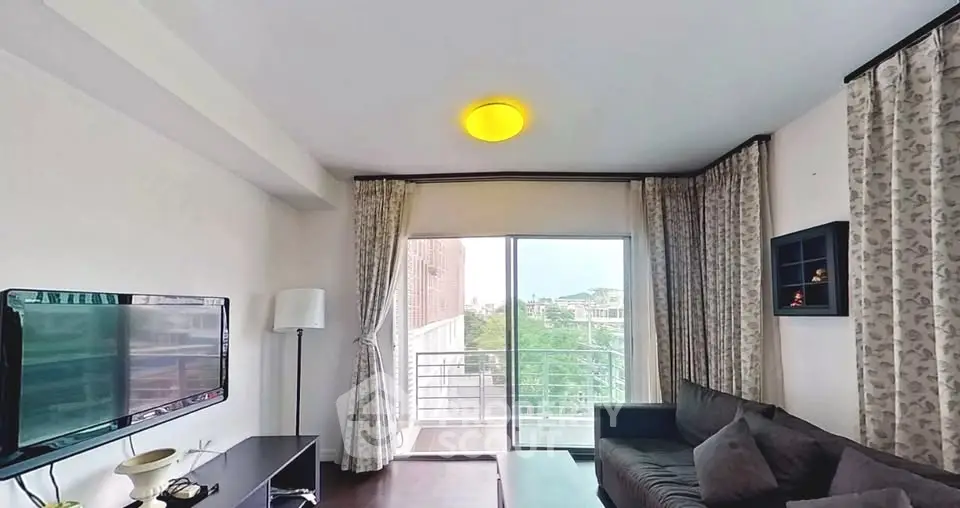 Modern living room with balcony view, stylish decor, and natural light.