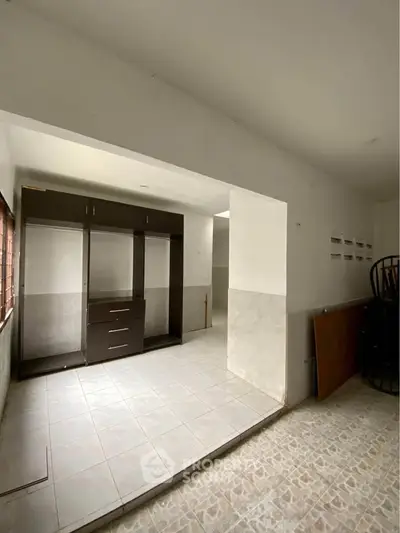Spacious interior with tiled flooring and built-in storage, ideal for versatile use.