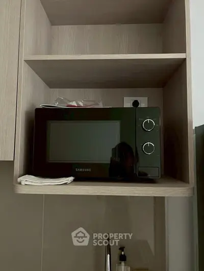 Modern kitchen with sleek microwave and wooden shelving