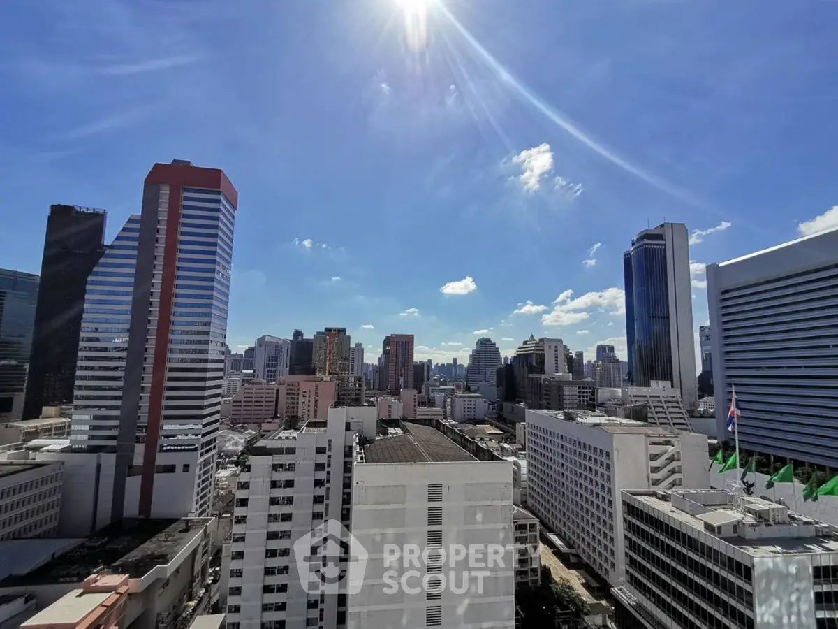 Stunning cityscape view from a high-rise building under a clear blue sky.