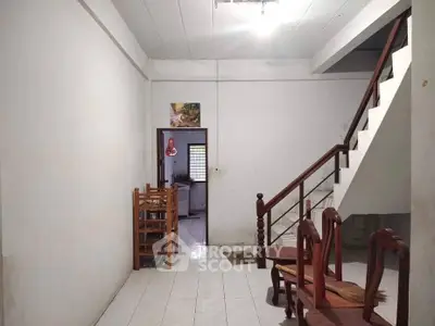 Spacious interior with staircase and dining area in a minimalist home setting.