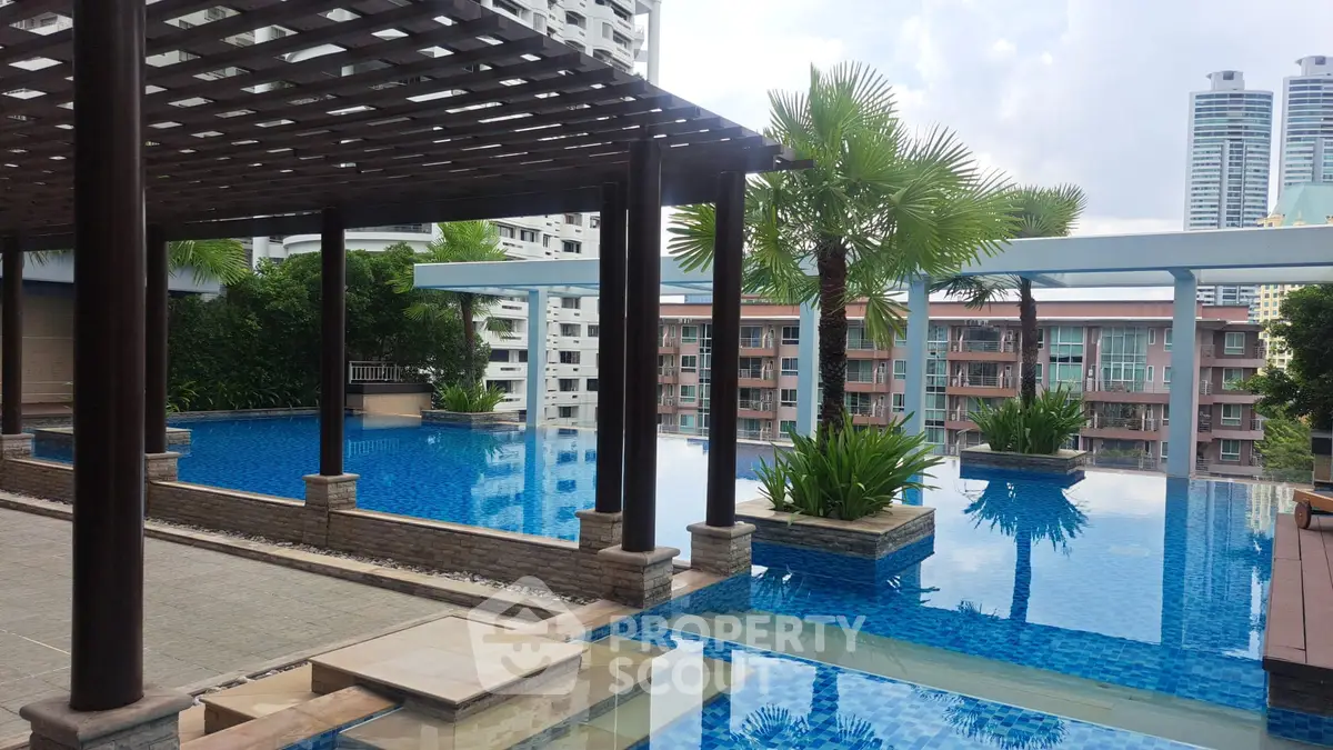 Luxurious rooftop pool with stunning city views and lush greenery, perfect for relaxation and leisure.