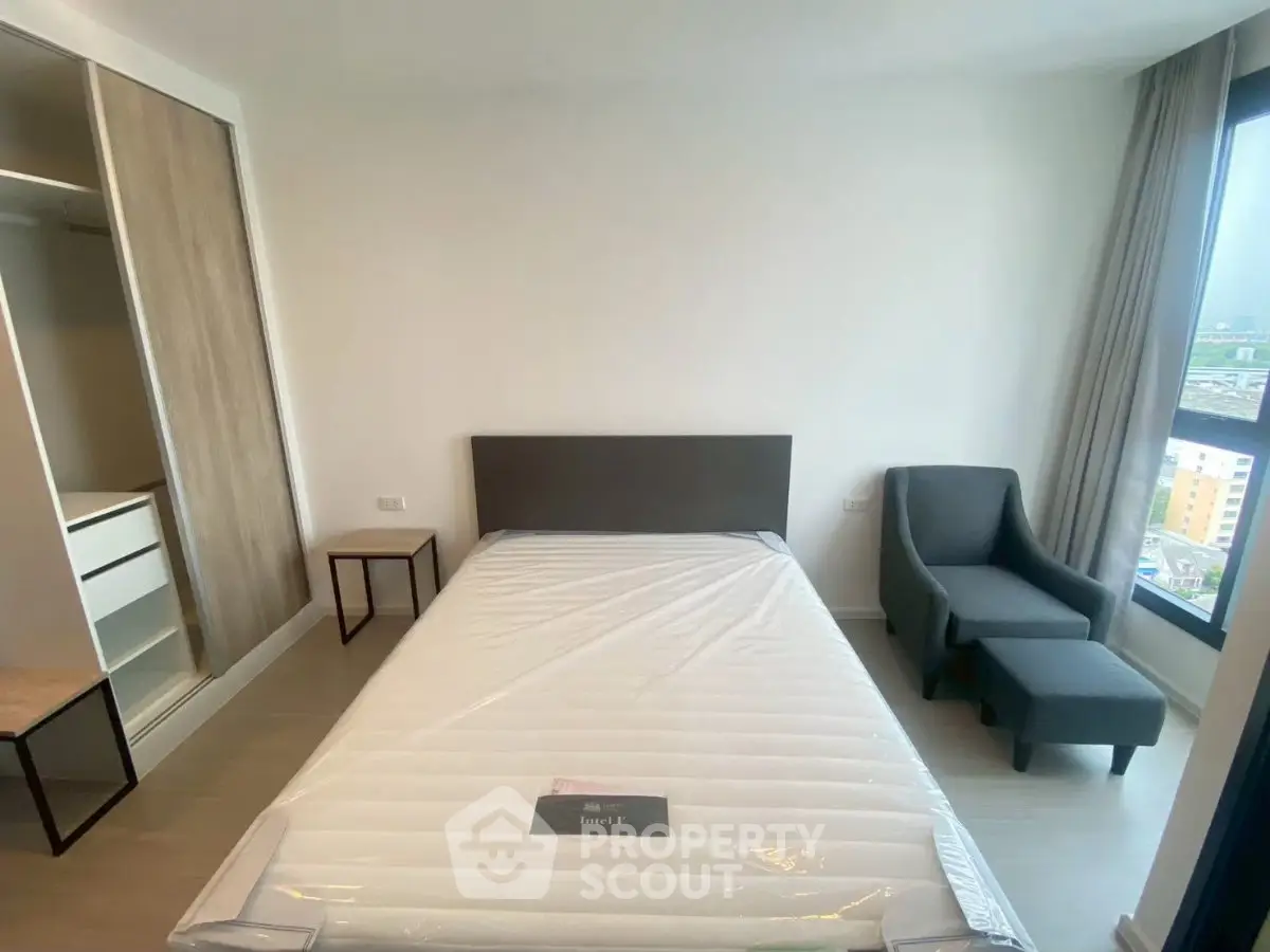 Modern bedroom with large window and comfortable furnishings in a stylish apartment.