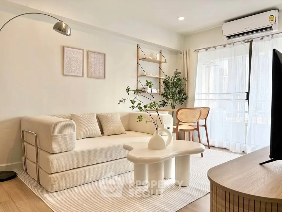 Modern living room with stylish furniture and natural light, featuring a cozy sofa and elegant decor.