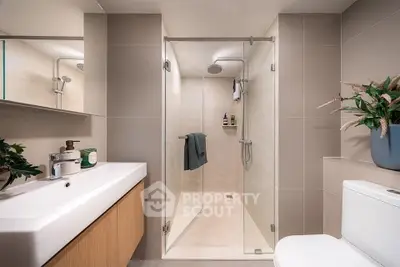 Modern bathroom with sleek shower, elegant sink, and stylish decor in a contemporary home.