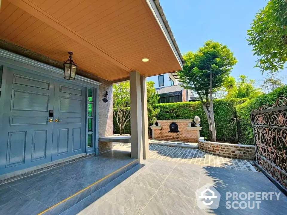 Charming entrance with elegant door and lush garden, perfect for welcoming guests.