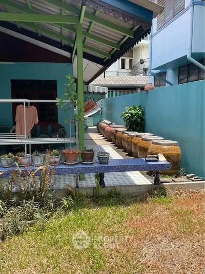Charming backyard with traditional pottery and lush greenery, perfect for outdoor relaxation and gardening.