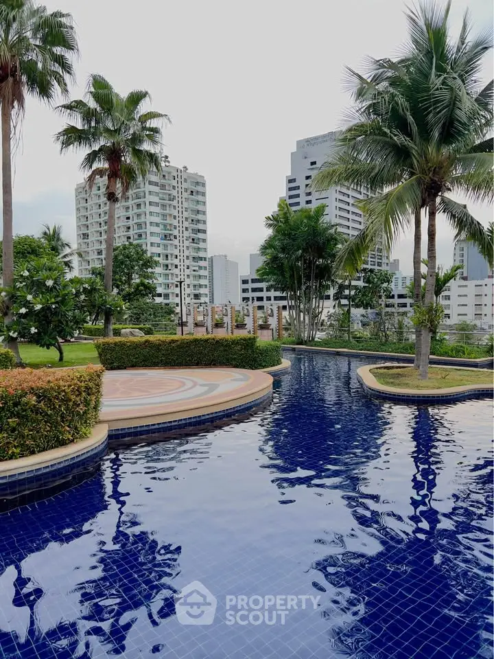 Luxurious poolside view with lush greenery and city skyline backdrop