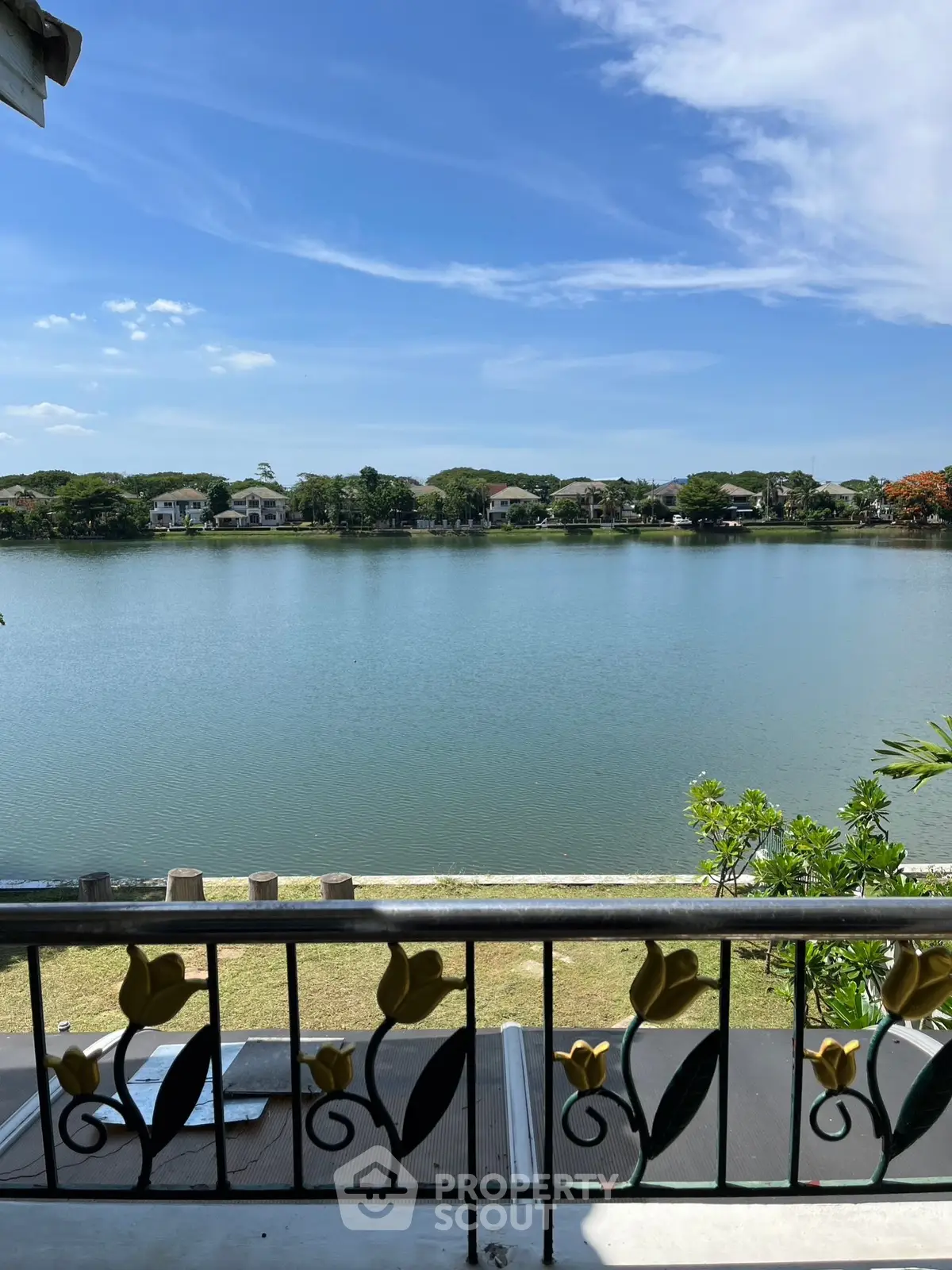 Stunning lakeside view from a balcony with clear blue skies and serene water.