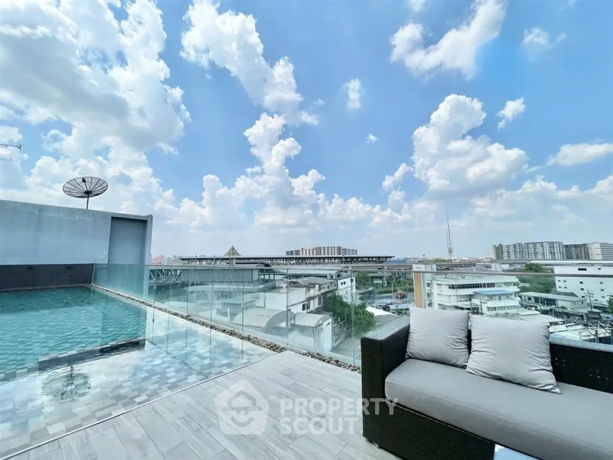 Stunning rooftop pool with panoramic city views and modern seating area.