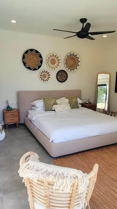 Stylish bedroom with modern decor and cozy ambiance, featuring a comfortable bed and unique wall art.