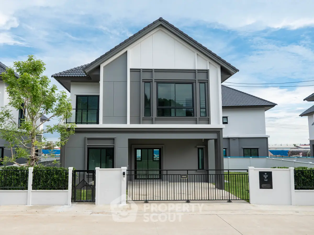 Modern two-story house with sleek design and spacious front yard in a serene neighborhood.