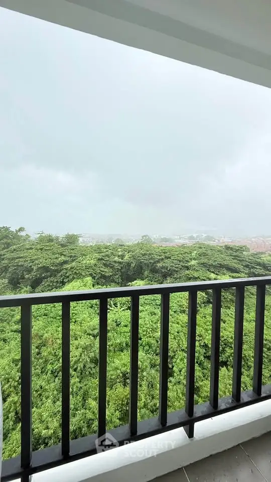 Stunning balcony view overlooking lush greenery and cityscape, perfect for nature lovers.