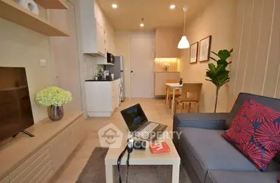 Modern living room with open kitchen, cozy seating, and stylish decor