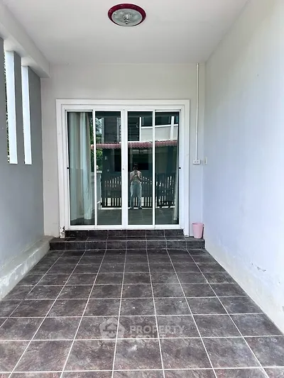 Spacious tiled balcony with sliding glass doors and natural light