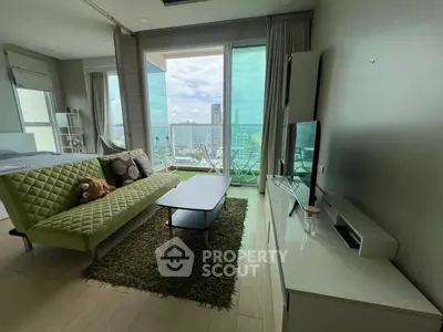 Modern living room with city view, stylish green sofa, and large windows for natural light.