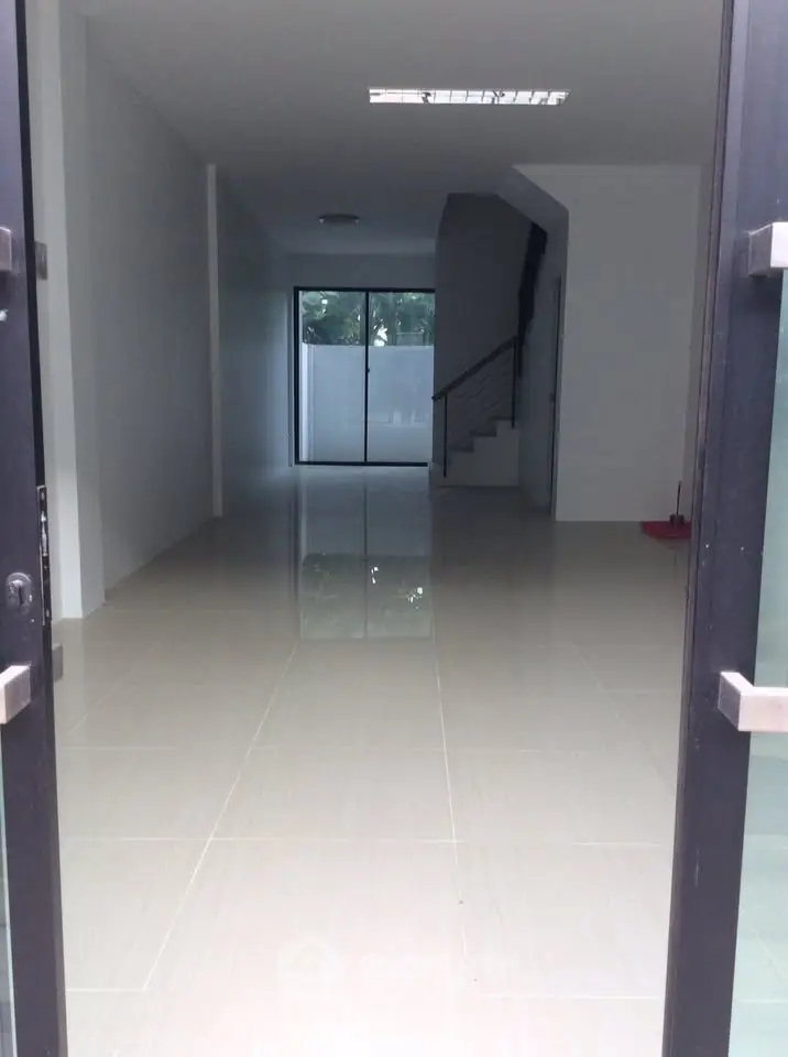 Spacious open-plan interior with sleek tiled flooring and modern staircase, ideal for customization.