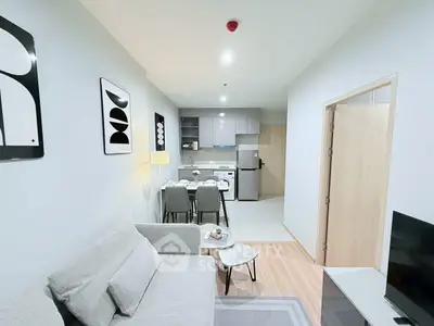 Modern open-plan living room and kitchen with stylish decor and neutral tones.