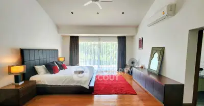 Spacious bedroom with modern decor and large window overlooking greenery, featuring a cozy bed and stylish furnishings.