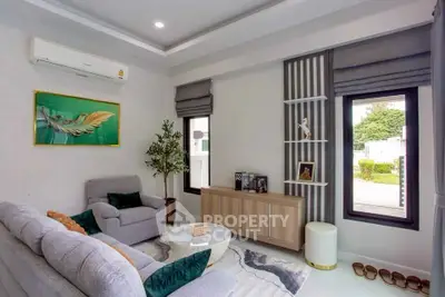Modern living room with stylish decor and natural light, featuring a cozy sofa and elegant furnishings.