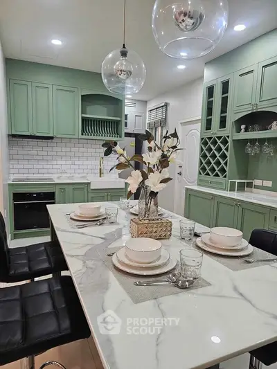 Elegant kitchen with marble island and mint green cabinets