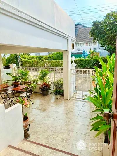 Charming garden patio with lush greenery and outdoor seating in a serene residential area.